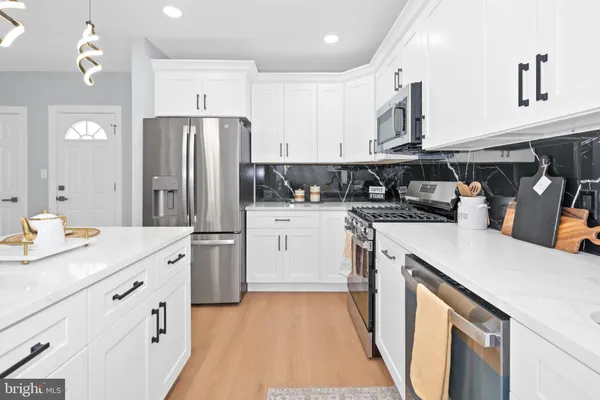 a kitchen with a sink a stove a refrigerator and cabinets