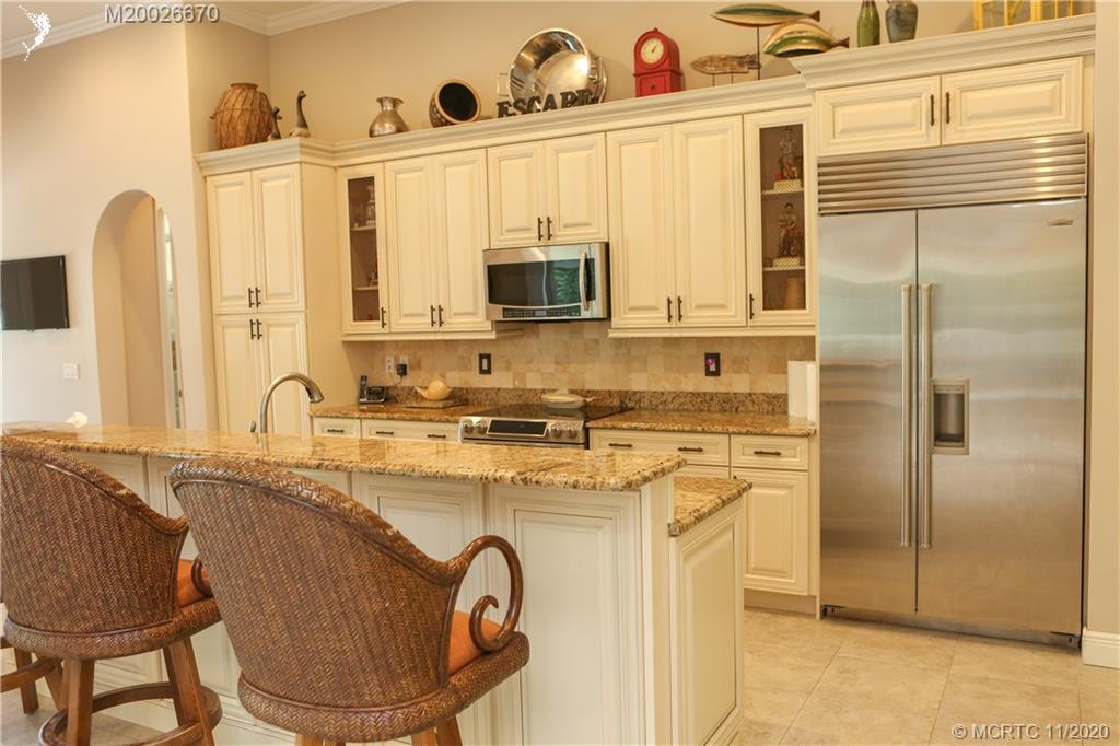 4961 Southeast Inlet Isle Way Stuart, FL 34997 - Photo 3 of 37 a kitchen with stainless steel appliances granite countertop a stove a sink and a refrigerator