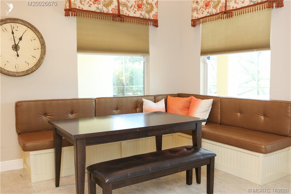4961 Southeast Inlet Isle Way Stuart, FL 34997 - Photo 6 of 37 a living room with a table a window and a clock