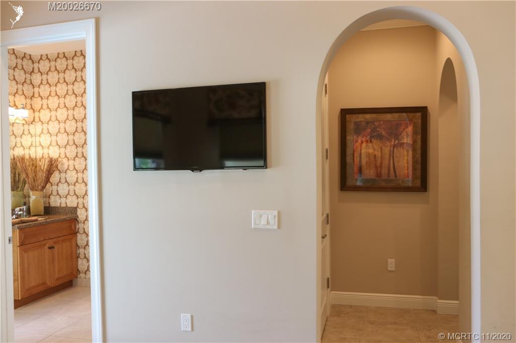 4961 Southeast Inlet Isle Way Stuart, FL 34997 - Photo 7 of 37 a view of a hallway with wooden floor and a bathroom