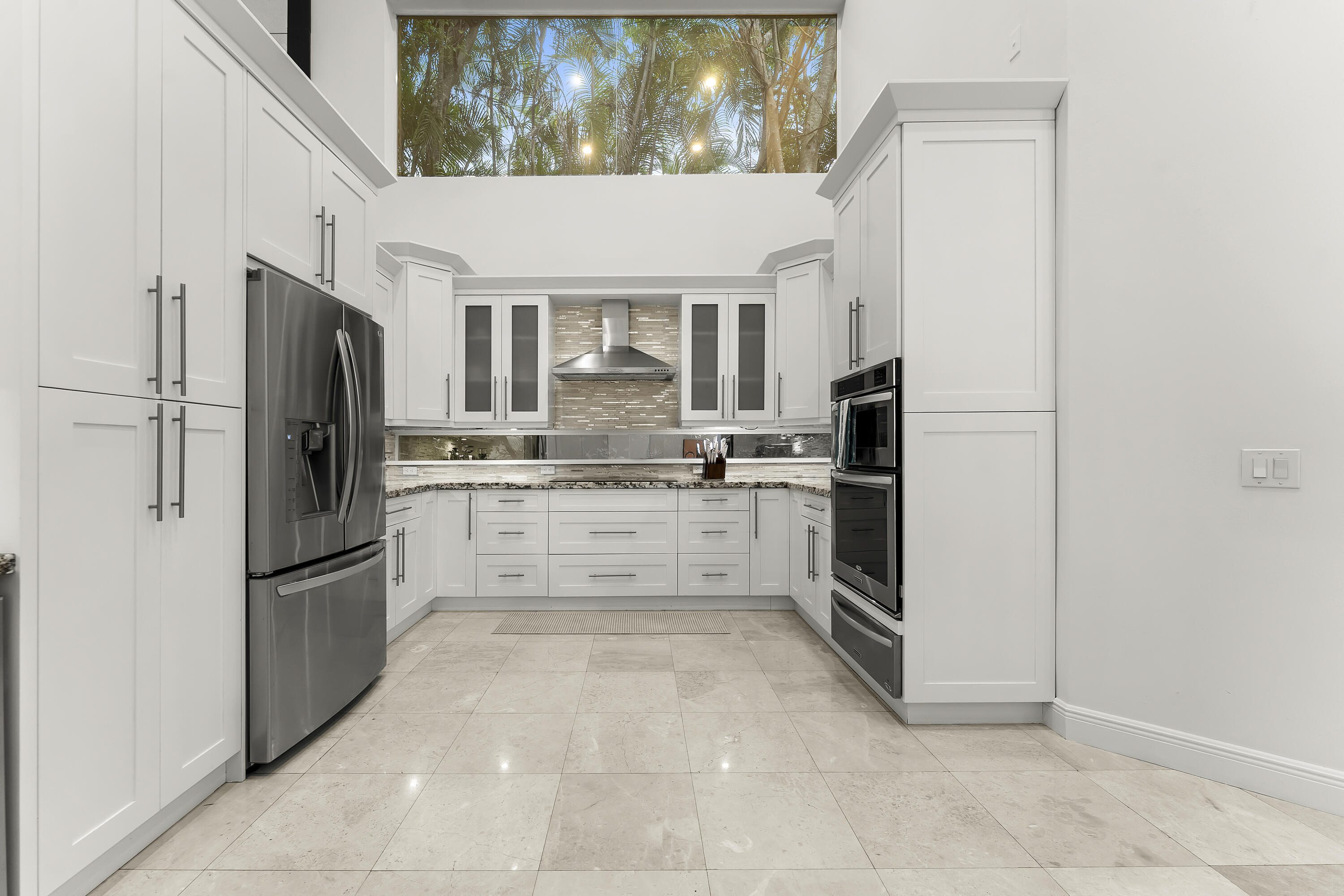 3156 Northwest 61st Street Boca Raton, FL 33496 - Photo 15 of 46 a kitchen with white cabinets and stainless steel appliances