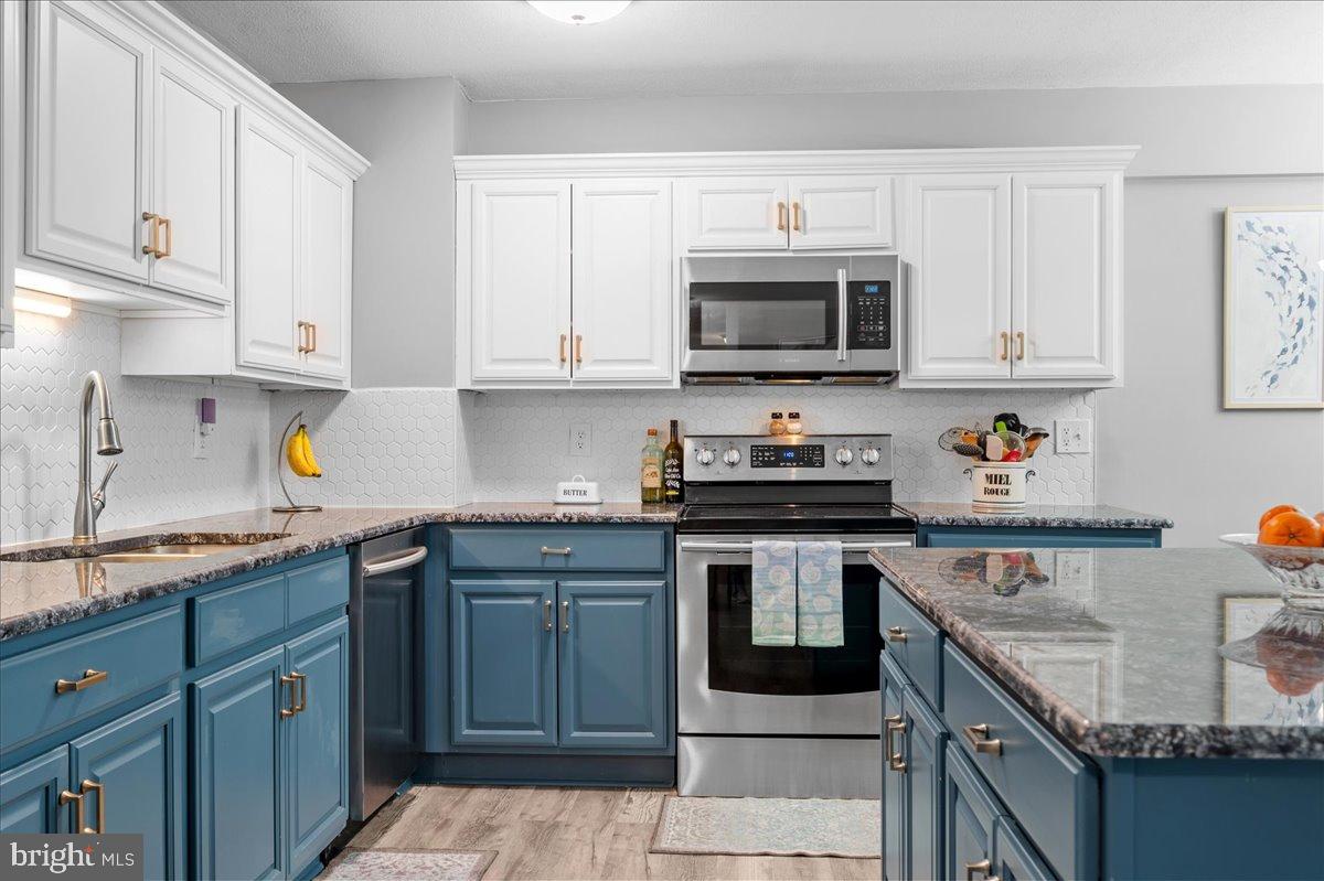 84 Welsh Tract Road, Unit 106 Newark, DE 19713 - Photo 9 of 32 a kitchen with stainless steel appliances granite countertop a sink stove and cabinets