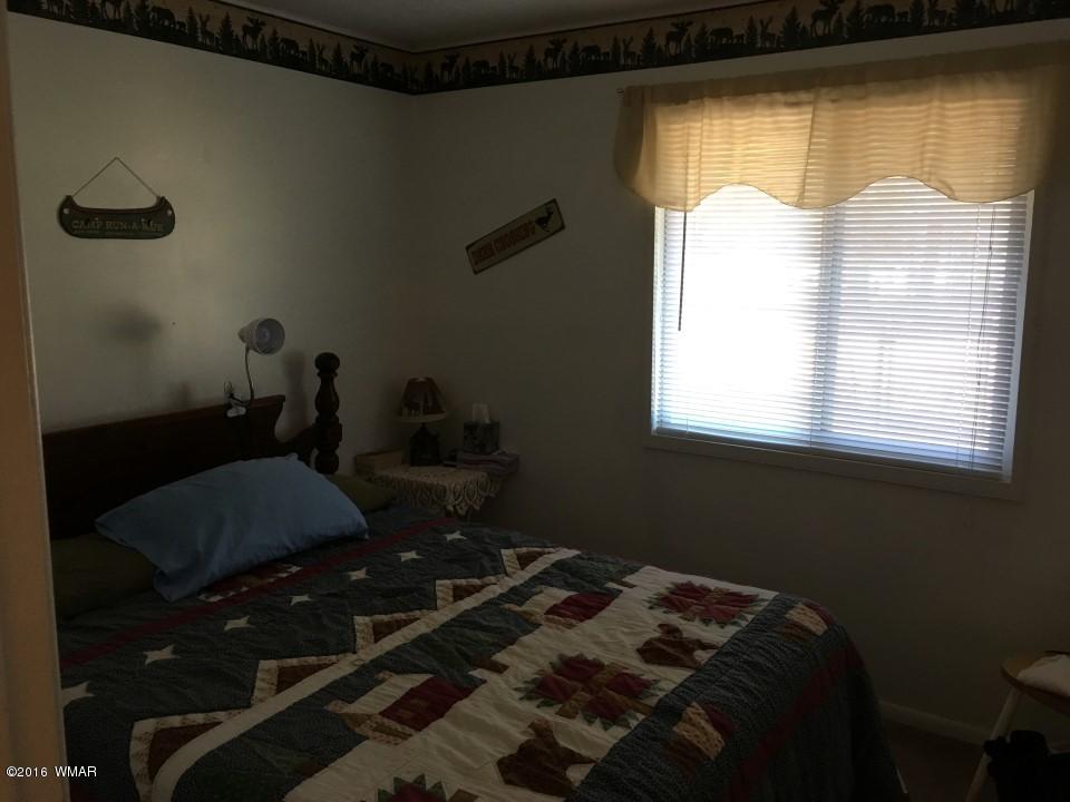 2846 Timber Trail Loop Overgaard, AZ 85933 - Photo 9 of 16 a bed sitting in a bedroom next to a window