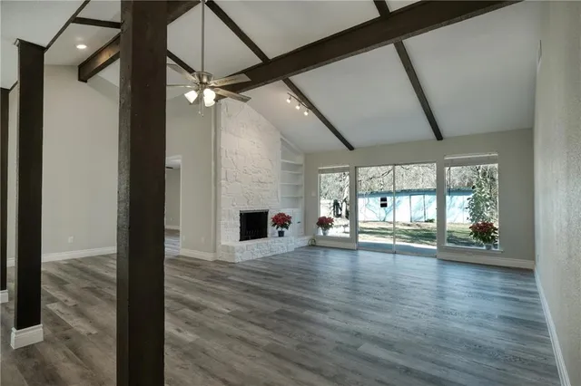 a view of empty room with wooden floor and fireplace