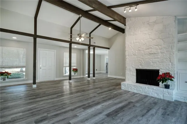 a view of empty room with wooden floor and fireplace