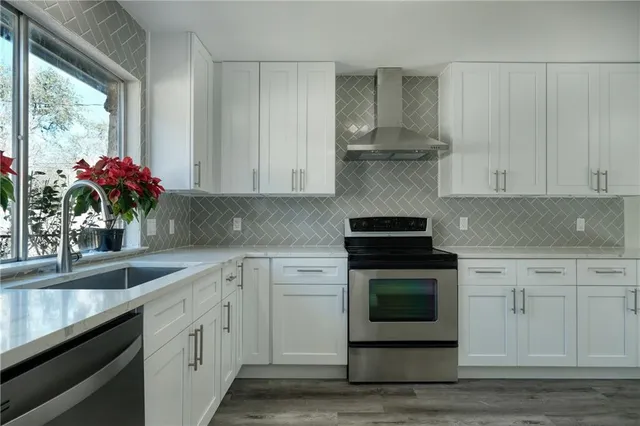 a kitchen with a refrigerator and white cabinets