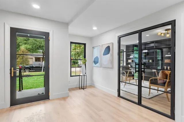 a living room with furniture a fireplace and a large window
