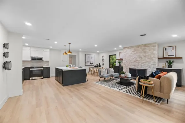 a living room with furniture a rug a fireplace and a window