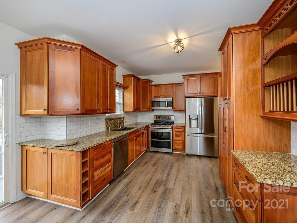 1446 Autumn Ridge Lane Fort Mill, SC 29708 - Photo 8 of 35 a kitchen with stainless steel appliances wooden floors and wooden cabinets