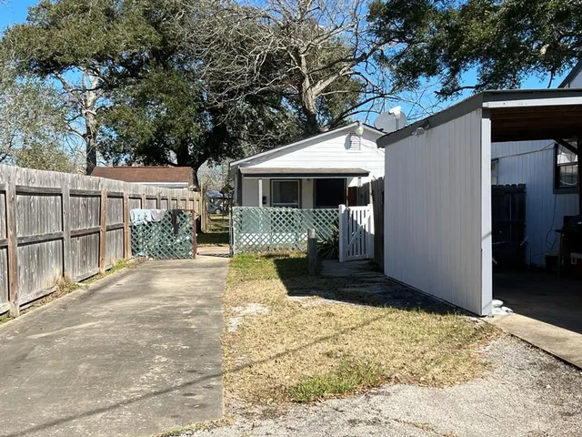 a view of a house with a yard and potted plants