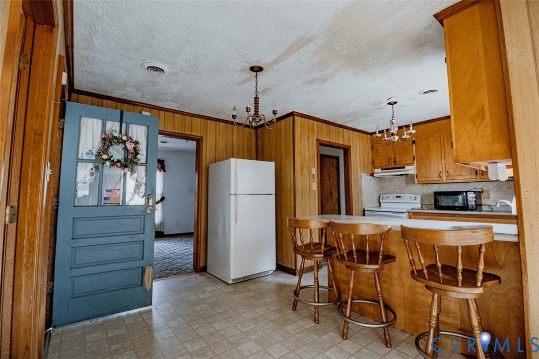 6710 Heritage Road Prince George, VA 23875 - Photo 9 of 27 a kitchen with refrigerator a table and chairs