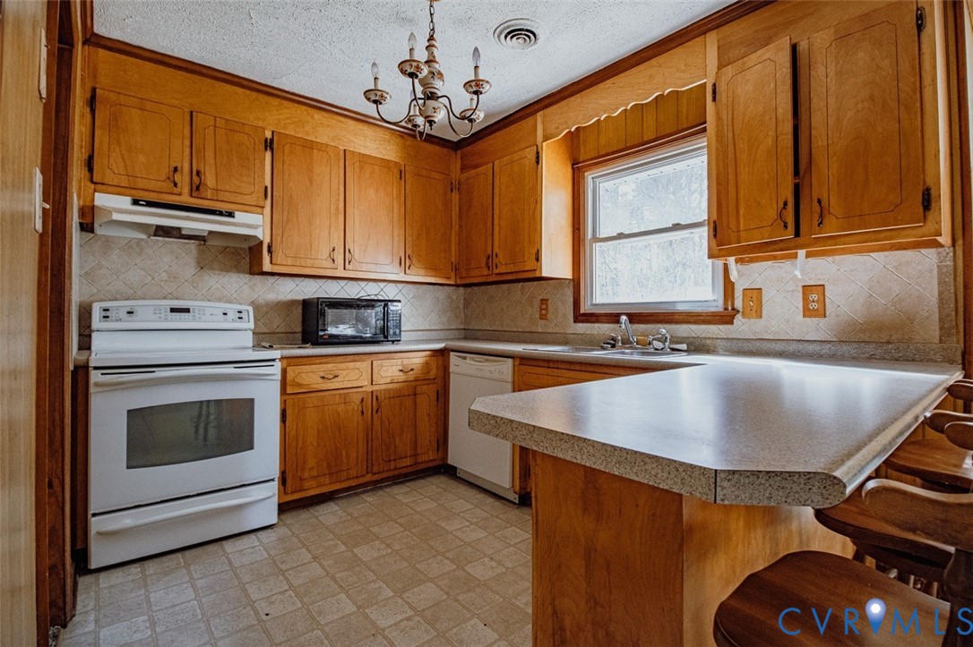 6710 Heritage Road Prince George, VA 23875 - Photo 10 of 27 a kitchen with stainless steel appliances granite countertop a sink a stove and a microwave