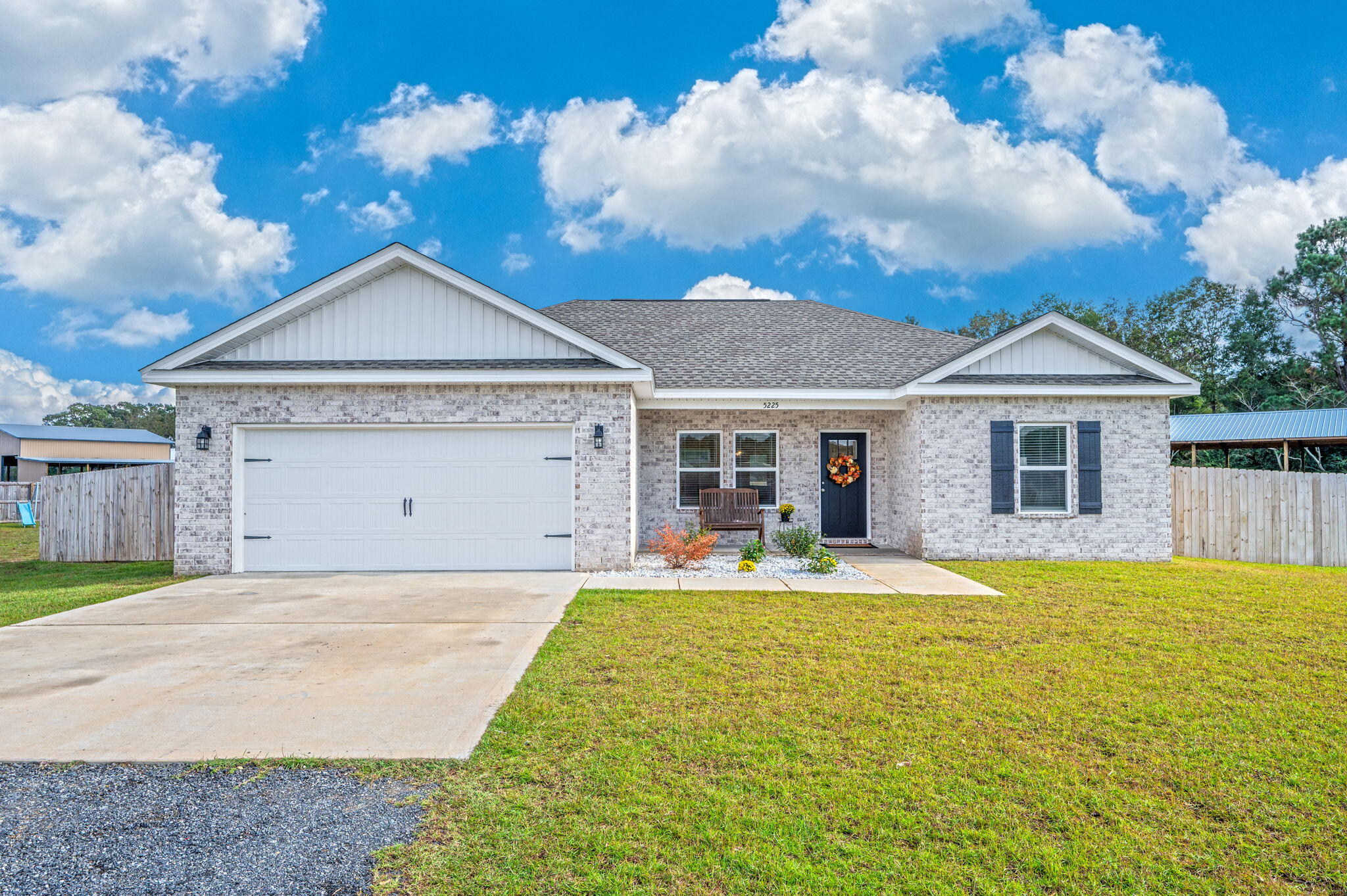 a front view of a house with a yard outdoor seating and garage