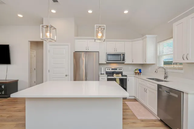 a kitchen with stainless steel appliances a refrigerator sink and microwave
