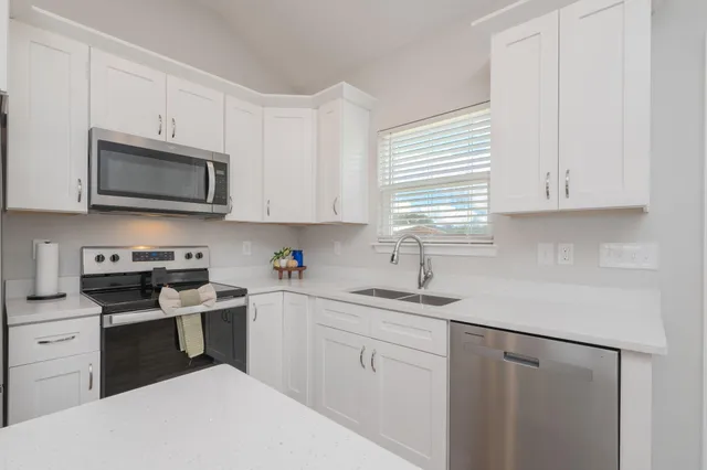 a kitchen with white cabinets and white appliances