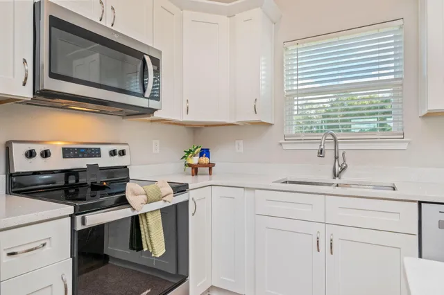 a kitchen with stainless steel appliances granite countertop a sink a stove and cabinets