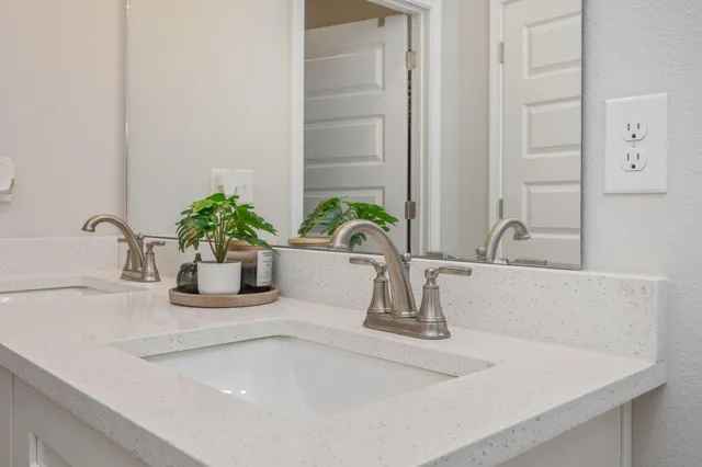 a en suite bathroom with a double vanity sink and a mirror
