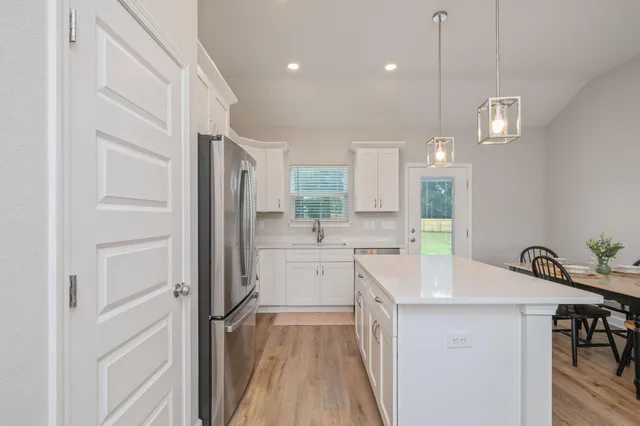 a kitchen with white cabinets and counter space