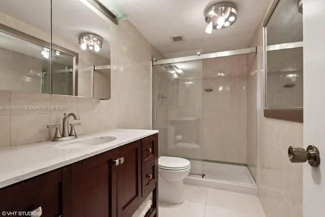 a bathroom with a double vanity sink toilet and shower