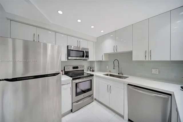 a kitchen with white cabinets stainless steel appliances and a sink