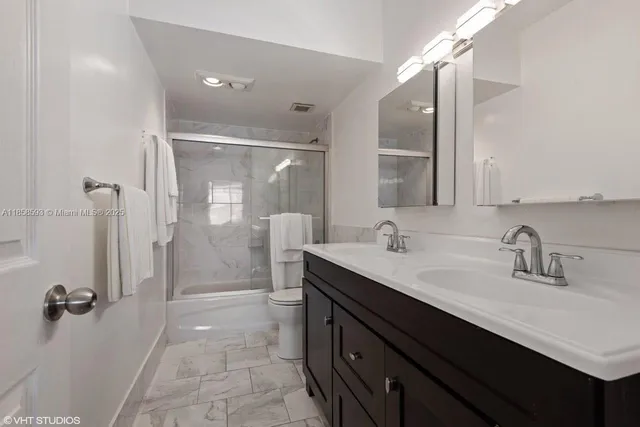 a bathroom with a double vanity sink mirror double and shower