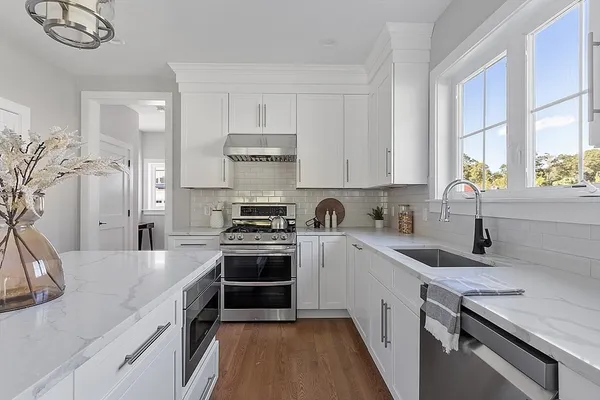 a kitchen with a sink stove top oven and cabinets