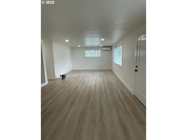 a view of an empty room with wooden floor