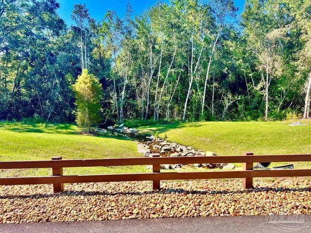 a view of a swimming pool with a patio and a yard