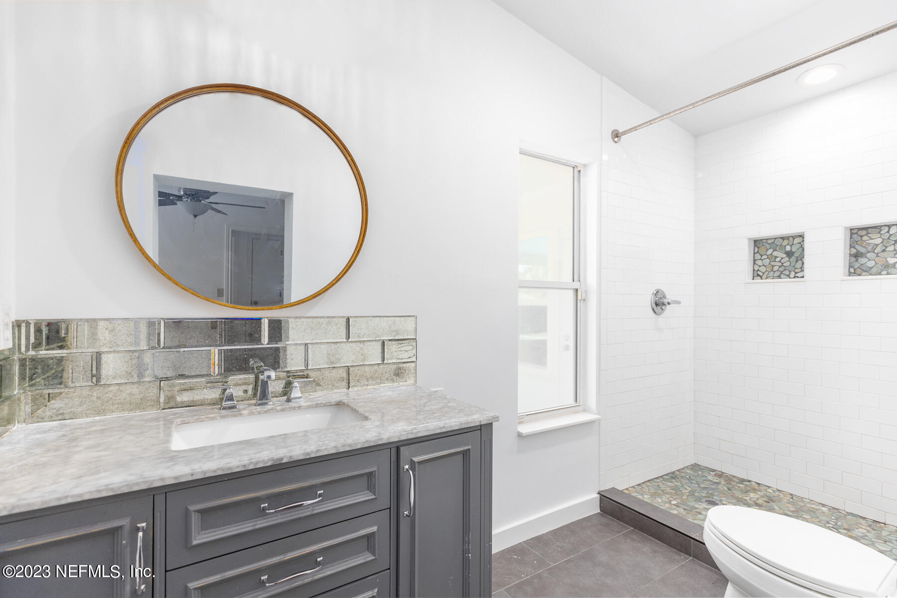 9 Amberjack Road Ponte Vedra Beach, FL 32082 - Photo 22 of 30 a bathroom with a granite countertop toilet a sink and a mirror