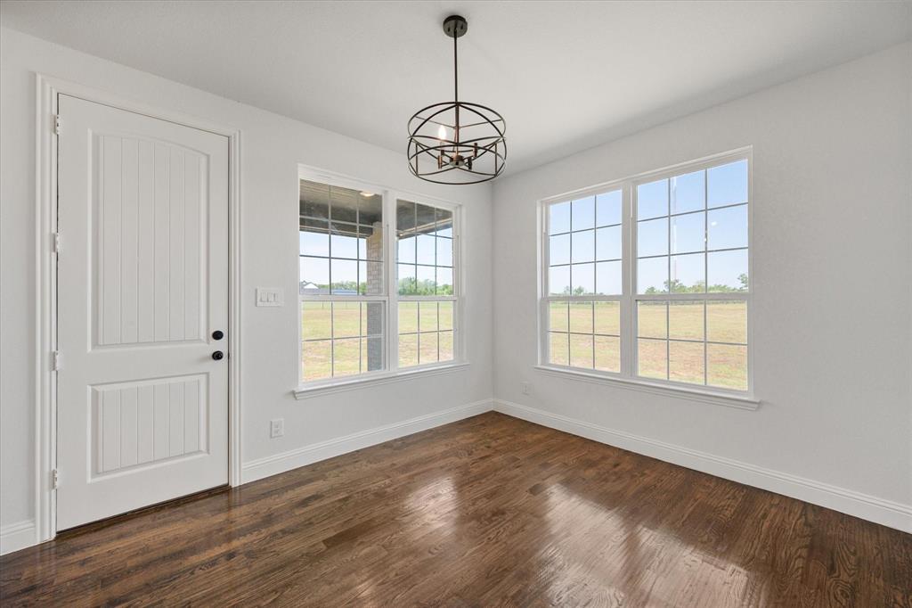 3400 Dobbins Road Corsicana, TX 75110 - Photo 16 of 40 an empty room with wooden floor fan and windows