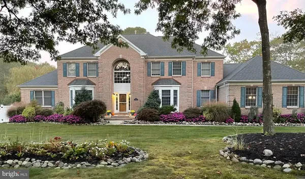 a front view of a house with a yard and potted plants