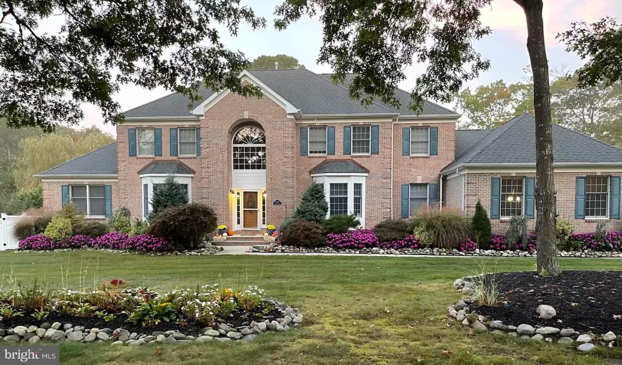 a front view of a house with a yard and potted plants