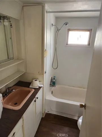 a bathroom with a tub sink and mirror