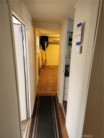 a view of a hallway with wooden floor and entryway