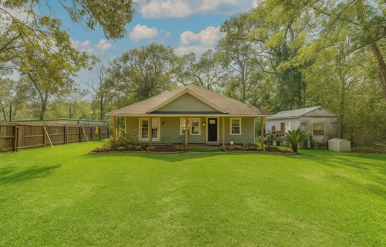 a front view of a house with yard and green space