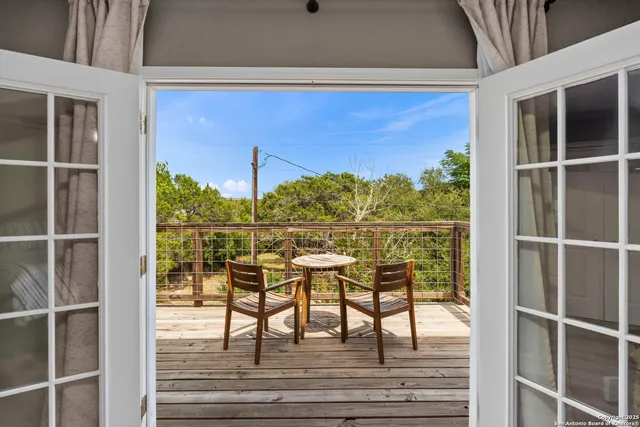 a view of a balcony with chairs and wooden floor