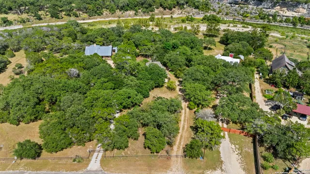 an aerial view of residential houses with outdoor space and trees