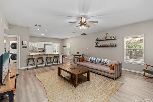 a living room with furniture a ceiling fan and a rug