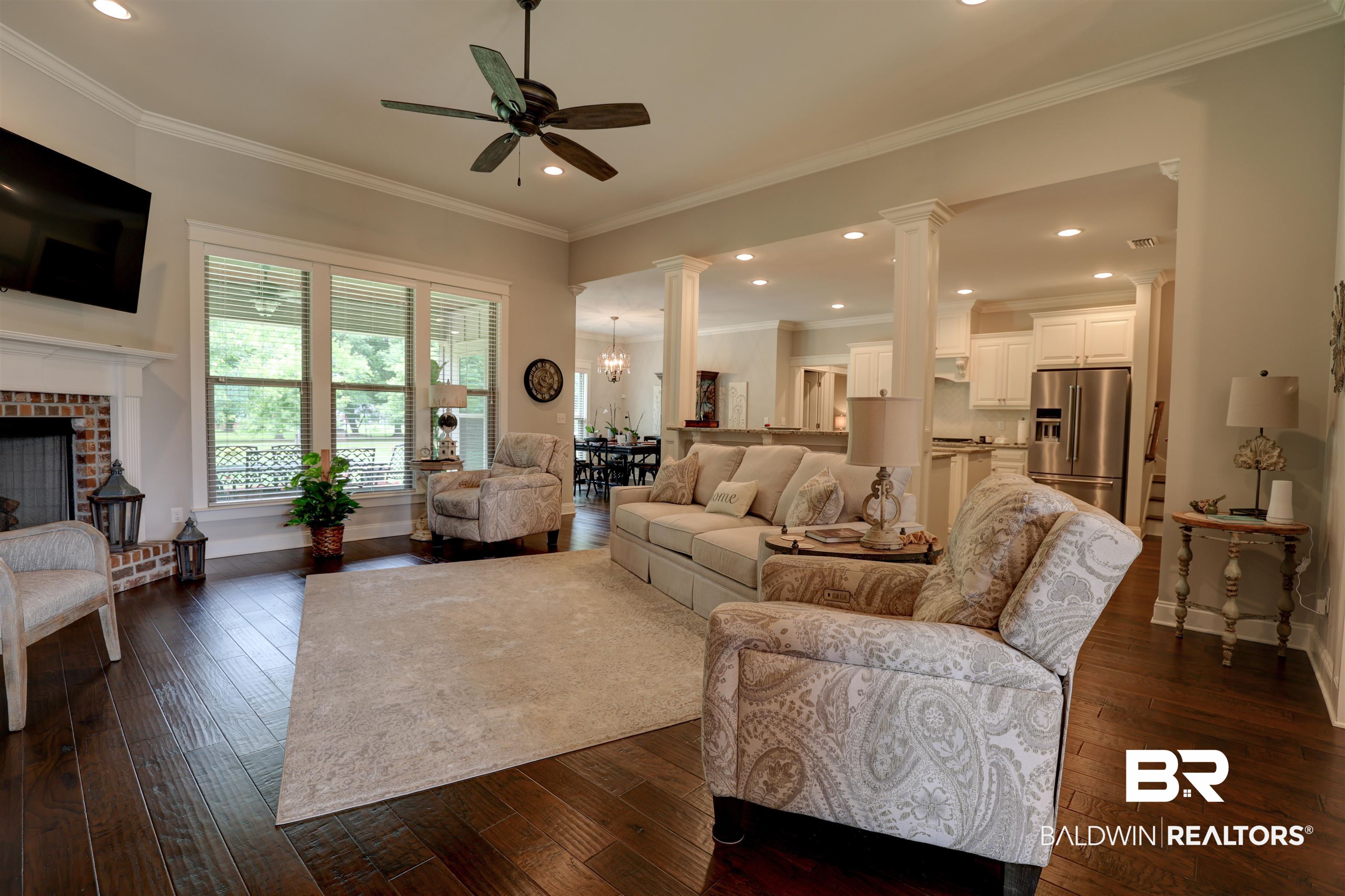 10588 Leesburg Pike Daphne, AL 36526 - Photo 25 of 29 Living room featuring dark hardwood / wood-style floors, ceiling fan with notable chandelier, a brick fireplace, and ornamental molding