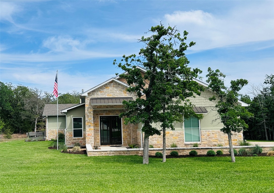 a front view of a house with a garden and trees