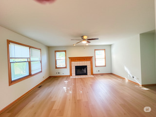 416 Fawn Lane Oswego, IL 60543 - Photo 7 of 13 wooden floor fireplace and windows in an empty room