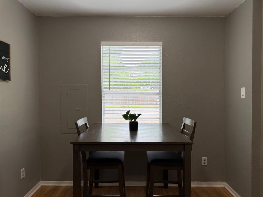 508 Batterson Street Cleburne, TX 76031 - Photo 15 of 28 Dining area featuring neutral wall tones, a single window with white blinds, and wood-finish flooring