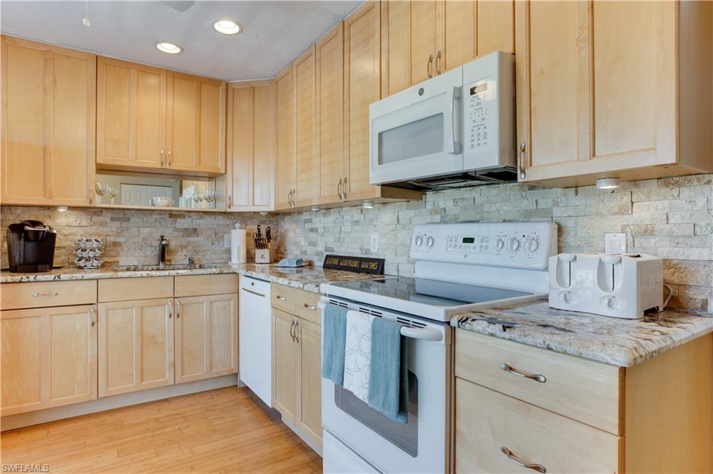 195 Harrison Road, Unit 4 Naples, FL 34112 - Photo 7 of 31 Plenty of cabinets, beautiful granite & backsplash