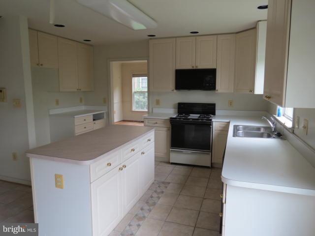2126 Queensguard Road Silver Spring, MD 20906 - Photo 4 of 25 a kitchen with granite countertop a sink and a stove top oven