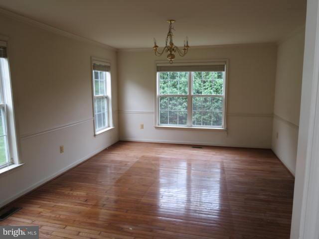 2126 Queensguard Road Silver Spring, MD 20906 - Photo 5 of 25 an empty room with wooden floor chandelier and windows