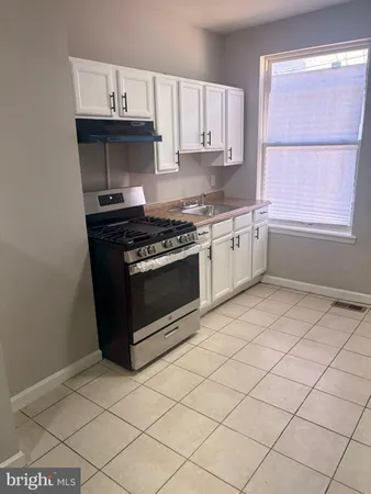 a kitchen with granite countertop a stove a sink and a microwave