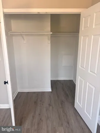 a view of walk in closet with wooden floor