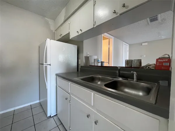 a kitchen with stainless steel appliances granite countertop a sink and a refrigerator
