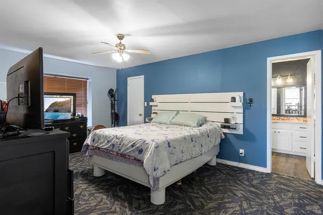 a bedroom with a bed and a flat tv screen on dresser