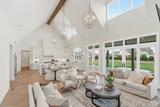 a living room with furniture kitchen view and large windows